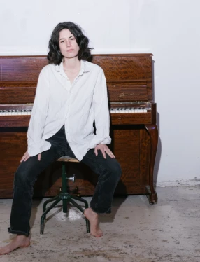 Hara Alonso sitter framför ett piano.