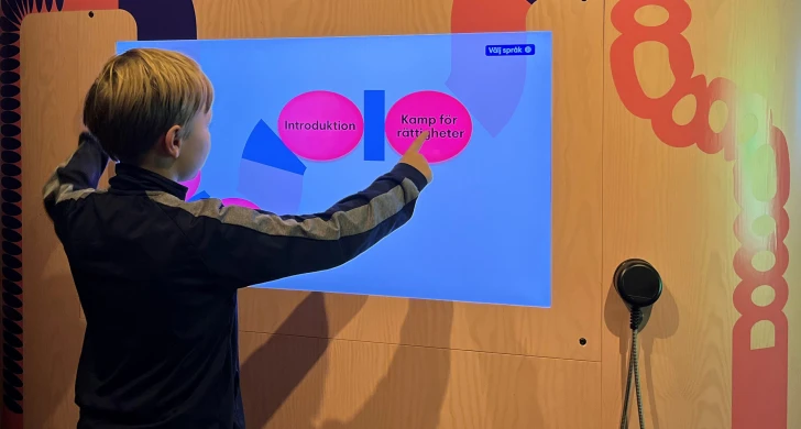 Ett barn trycker på en skärm om Kamp för rättigheter.