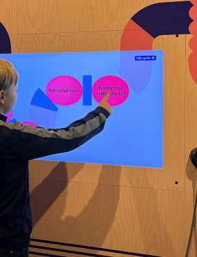 Ett barn trycker på en skärm om Kamp för rättigheter.