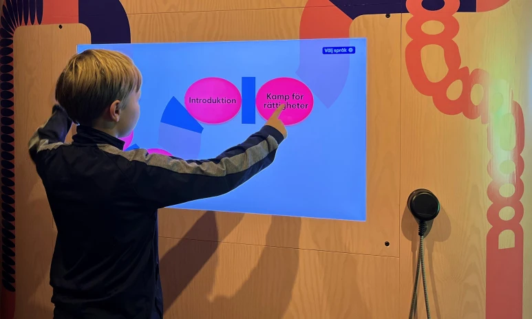 Ett barn trycker på en skärm om Kamp för rättigheter.