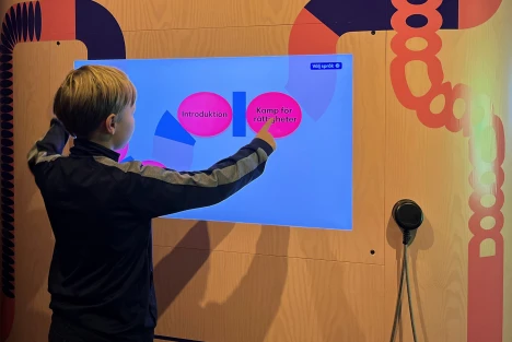 Ett barn trycker på en skärm om Kamp för rättigheter.