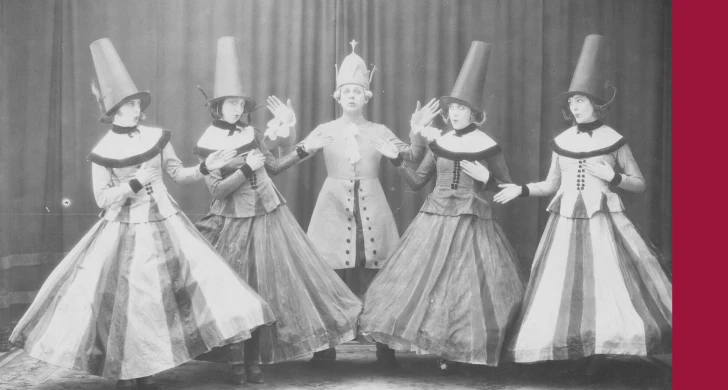 Ett svartvitt fotografi av fem dansare från Svenska Baletten i Paris under 1920-talet, i uppsättningen "De fåvitska jungfrurna". Till höger ligger ett tjockt streck i hallonrött.