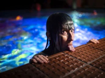 Konstnär Pipilotti Rist sträcker ut tungan och vilar den på poolkanten
