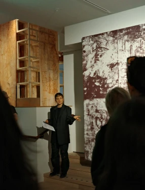 Curator visar en utställning för en stående publik.