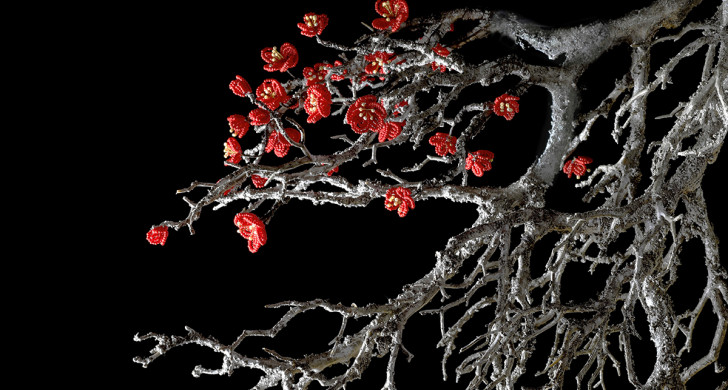 Svartvit träkvist med röda pärlblommor