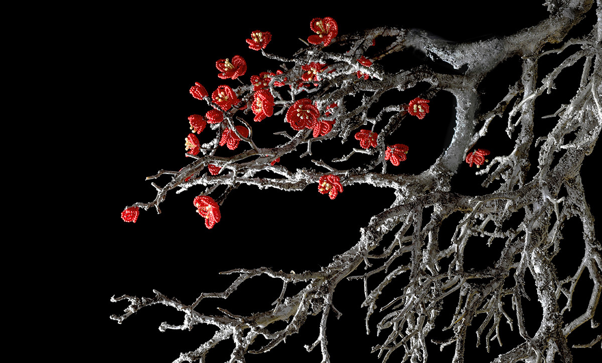Svartvit träkvist med röda pärlblommor