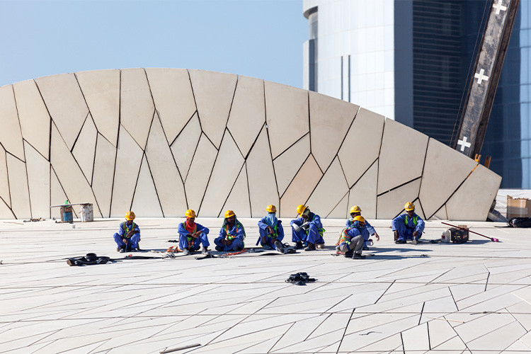 Byggarbetare sittandes på rad/Construction workers sitting in a line