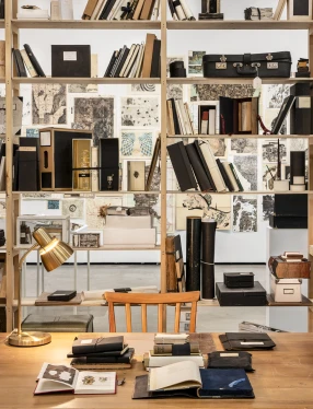 Skrivbord, bokhylla, skrivbordslampa.